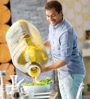 Guy pouring olive oil on the salad